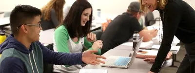 students working with faculty in classroom