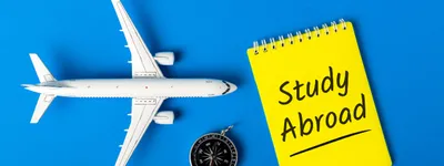 stock photo of a toy airplane with a notebook that says "Study Abroad"