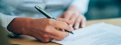 Person signing a piece of paper